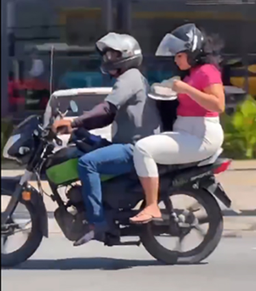 VÍDEO de mulher no trânsito comendo uma marmita na garupa de uma moto viraliza